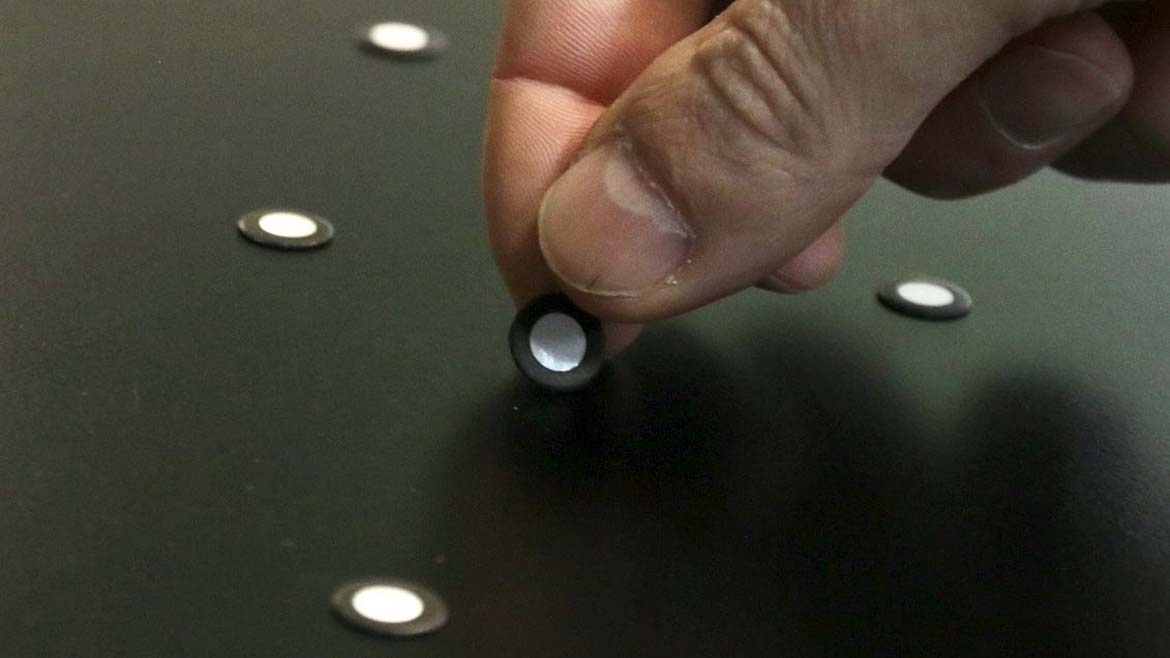 Close-up of a hand placing magnetic retro-reflective targets