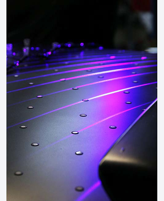 Close-up of object being scanned using magnetic retro-reflective targets. It's dimly lit with a purple glow and a blurred background.