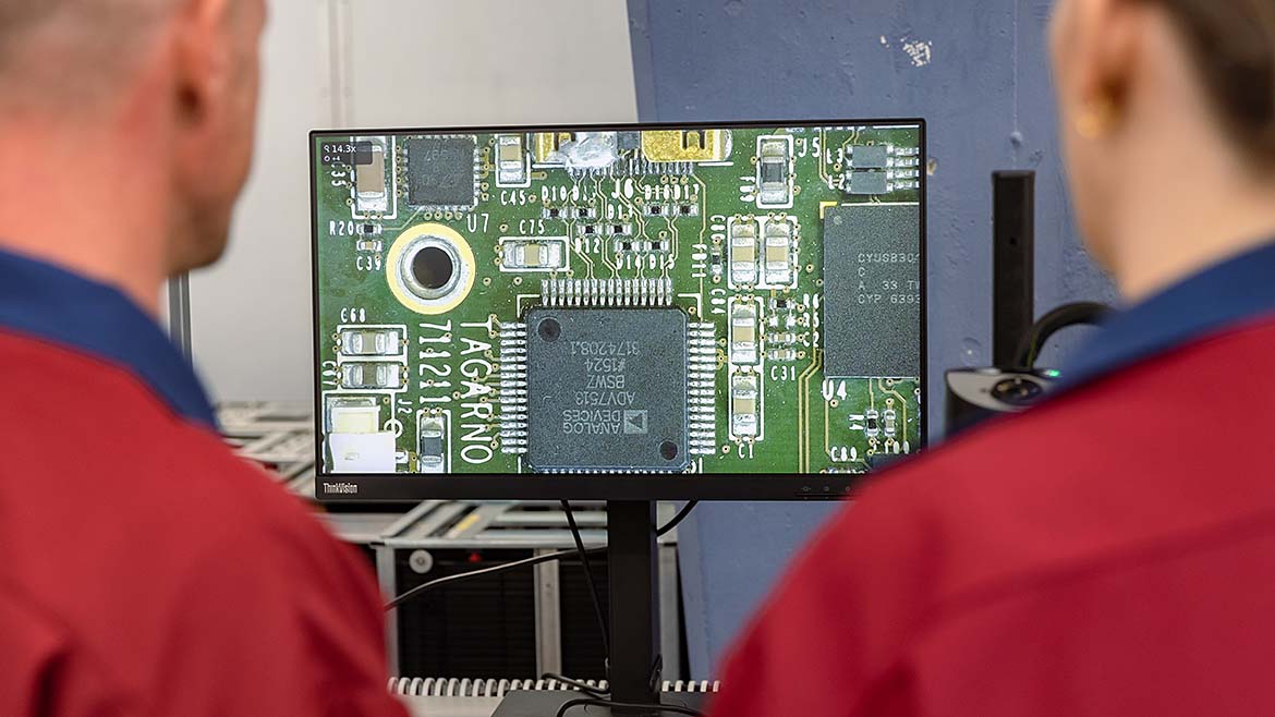 Two men looking at monitor screen using visual AI.