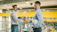 two industrial workers shaking hands two industrial workers shaking hands