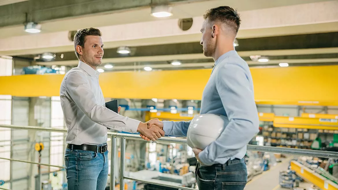 two industrial workers shaking hands