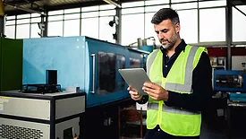 a mid-adult male factory worker in protective gear
