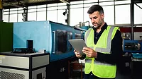 a mid-adult male factory worker in protective gear