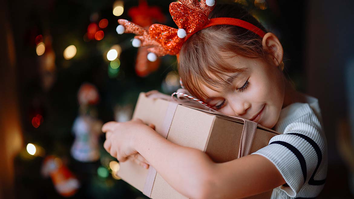 Child hugging a christmas present