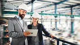 The image depicts industrial engineers at a manufacturing or industrial facility
