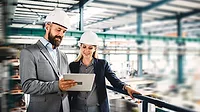 The image depicts industrial engineers at a manufacturing or industrial facility The image depicts industrial engineers at a manufacturing or industrial facility