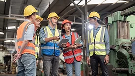 This image shows a group of quality supervisors in an industrial setting