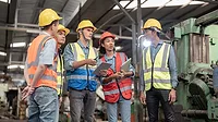 This image shows a group of quality supervisors in an industrial setting This image shows a group of quality supervisors in an industrial setting