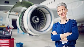 an aviation mechanic standing in an aircraft maintenance facility