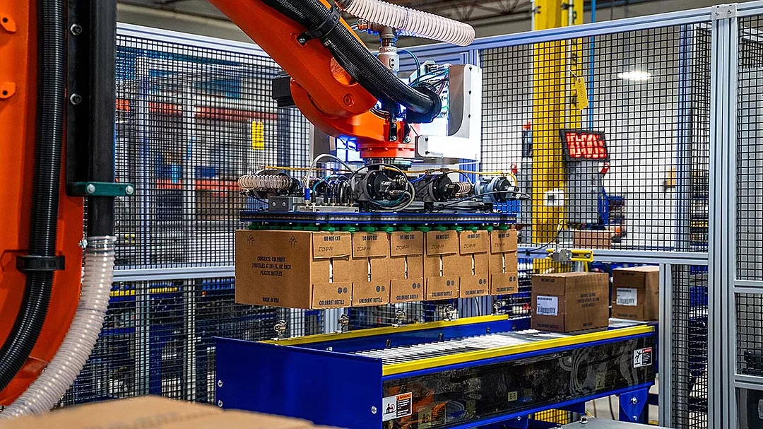 This image shows a KUKA industrial robot system used for automated packaging or palletizing