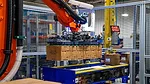 This image shows a KUKA industrial robot system used for automated packaging or palletizing