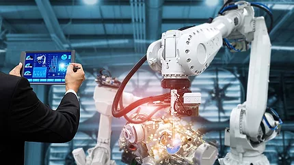 The image illustrates industrial robotic automation controlled by a manager or engineer using a tablet.