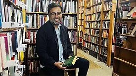 a man, potentially an author, in a bookstore setting
