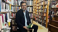 a man, potentially an author, in a bookstore setting a man, potentially an author, in a bookstore setting