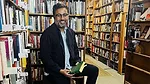 a man, potentially an author, in a bookstore setting