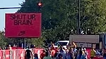 a large red Nike billboard with the text "SHUT UP, BRAIN" positioned along a marathon route