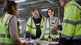 a moment of a multiracial team of construction workers and engineers discussing a construction project blueprint or plan