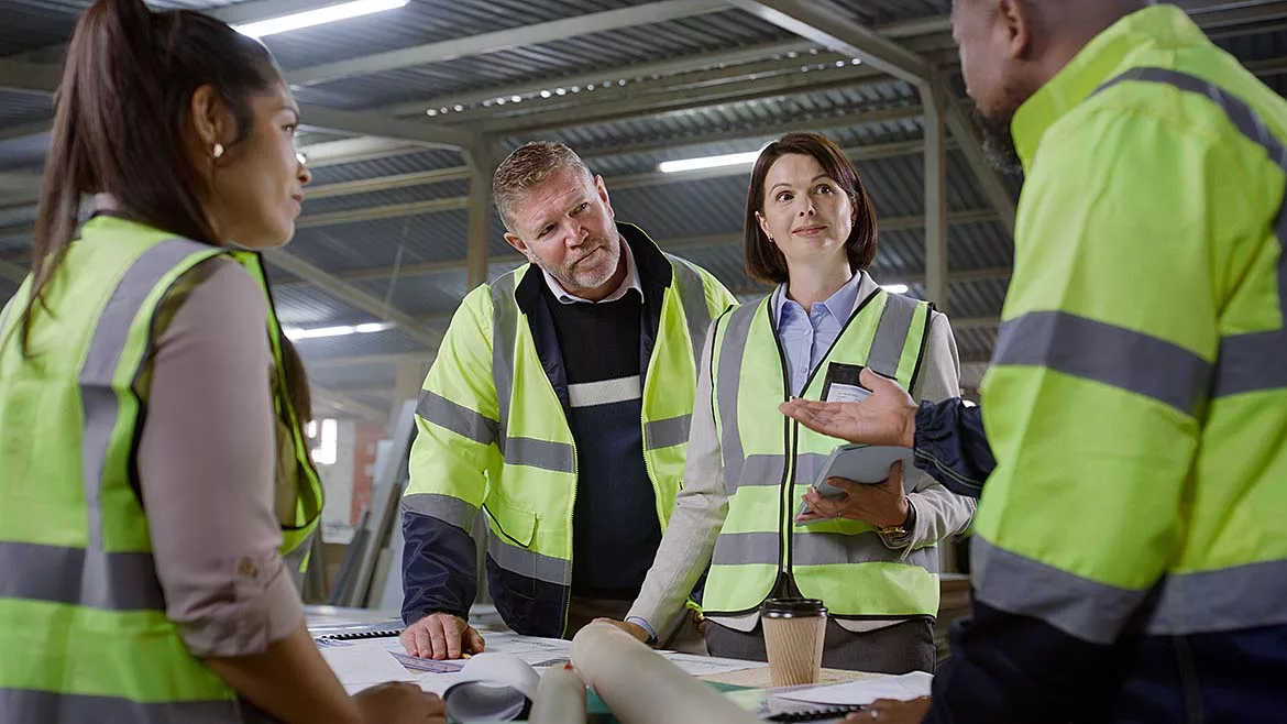 a moment of a multiracial team of construction workers and engineers discussing a construction project blueprint or plan
