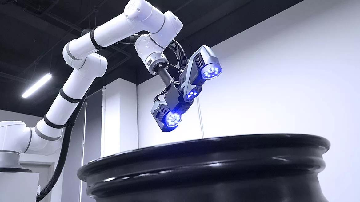This image shows an automated industrial inspection system using a KSCAN-E 3D scanner mounted on a robotic arm. 
