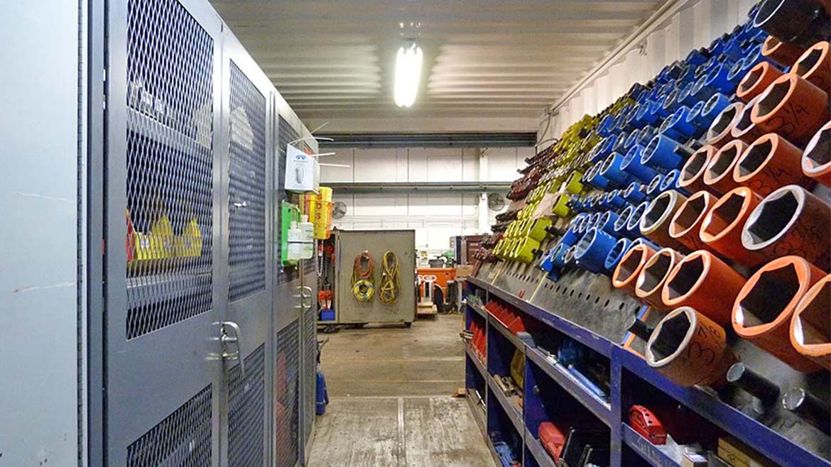 The image depicts the interior of a warehouse or industrial storage area.