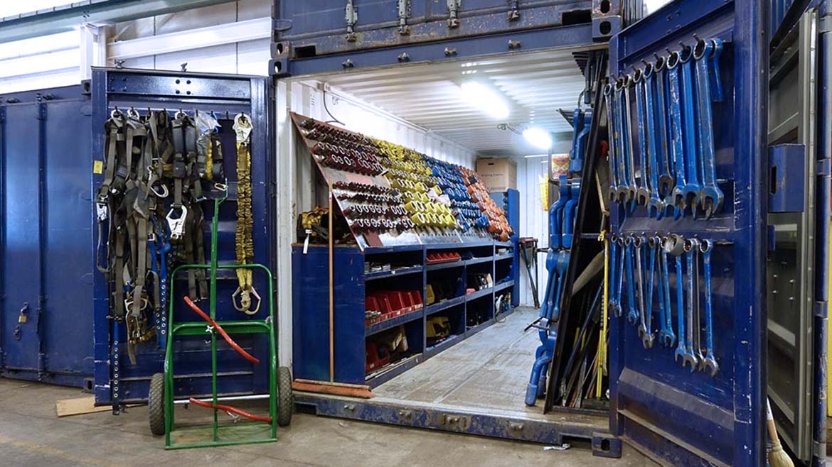 This image shows a shipping container converted into a portable workshop or secure on-site tool storage unit.  I