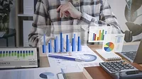 This image depicts a business professional analyzing financial data 
