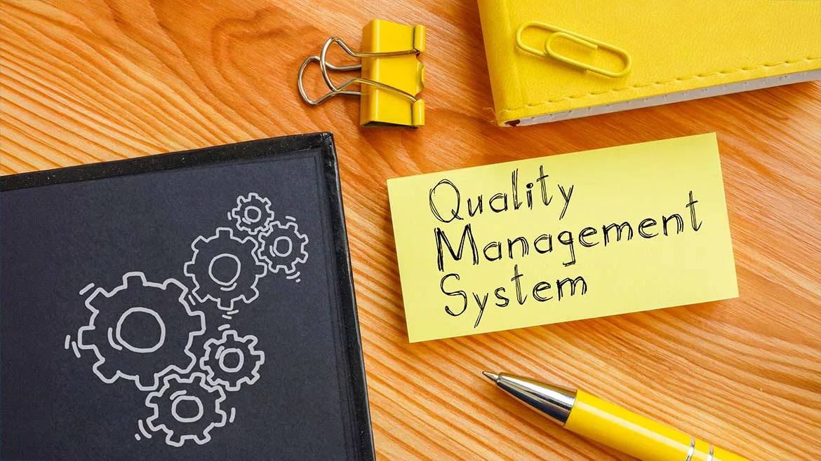The image highlights the concept of a Quality Management System (QMS).
