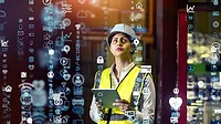 This image depicts a logistics manager using a tablet to monitor an automated supply chain system. This image depicts a logistics manager using a tablet to monitor an automated supply chain system.