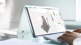 The image features a Microsoft Surface Book running software to enhance data-driven processes for additive manufacturing (AM). 