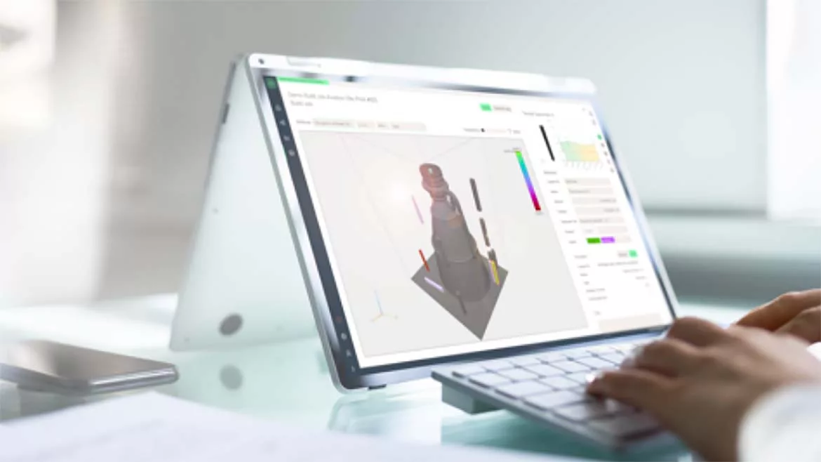 The image features a Microsoft Surface Book running software to enhance data-driven processes for additive manufacturing (AM).