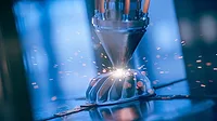 The image depicts metal 3D printing, also known as additive manufacturing. The image depicts metal 3D printing, also known as additive manufacturing.