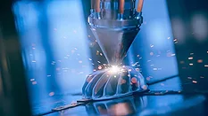 The image depicts metal 3D printing, also known as additive manufacturing. 