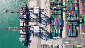 This image shows a container terminal, a crucial node in global supply chain logistics where cargo ships are loaded and unloaded.