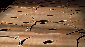 This image shows a metal sheet being processed using CNC plasma cutting technology. 