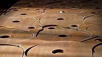 This image shows a metal sheet being processed using CNC plasma cutting technology. 
