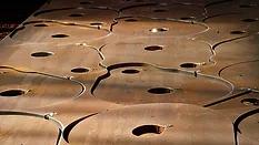 This image shows a metal sheet being processed using CNC plasma cutting technology. 