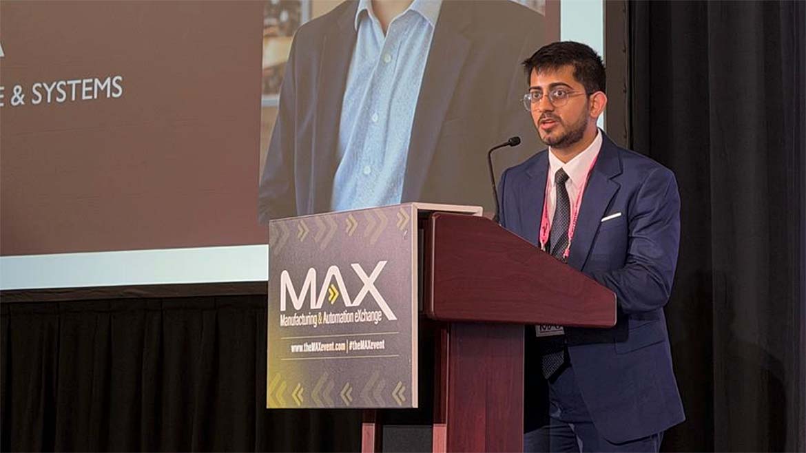 Arora speaking at a podium during the Manufacturing & Automation eXchange (MAX)