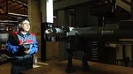 a person using a handheld device to interact with a large piece of industrial machinery or specialized equipment in a workshop setting.