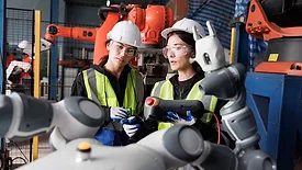 This image depicts a female engineer checking a prototype automation robot arm in a research and development robotic factory. 