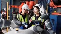This image depicts a female engineer checking a prototype automation robot arm in a research and development robotic factory. 
