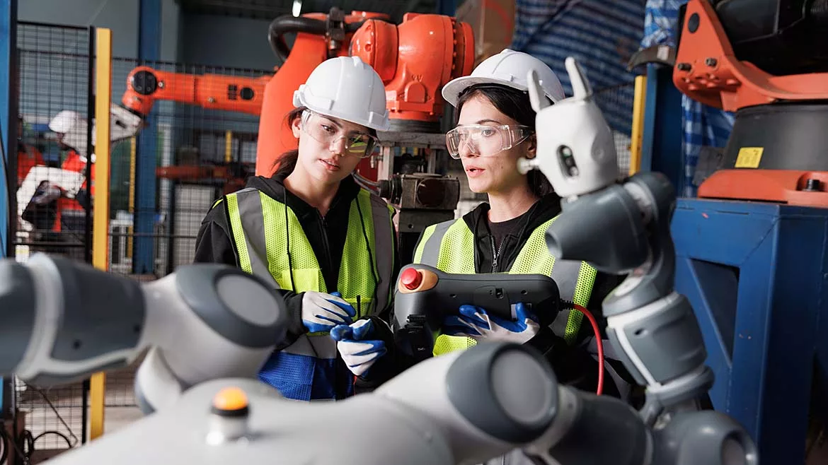 This image depicts a female engineer checking a prototype automation robot arm in a research and development robotic factory. 
