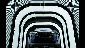 This image shows a Nissan vehicle undergoing quality inspection in an automotive manufacturing plant. 