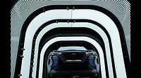 This image shows a Nissan vehicle undergoing quality inspection in an automotive manufacturing plant. 
