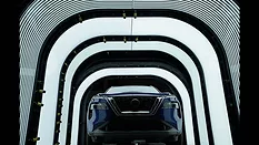This image shows a Nissan vehicle undergoing quality inspection in an automotive manufacturing plant. 