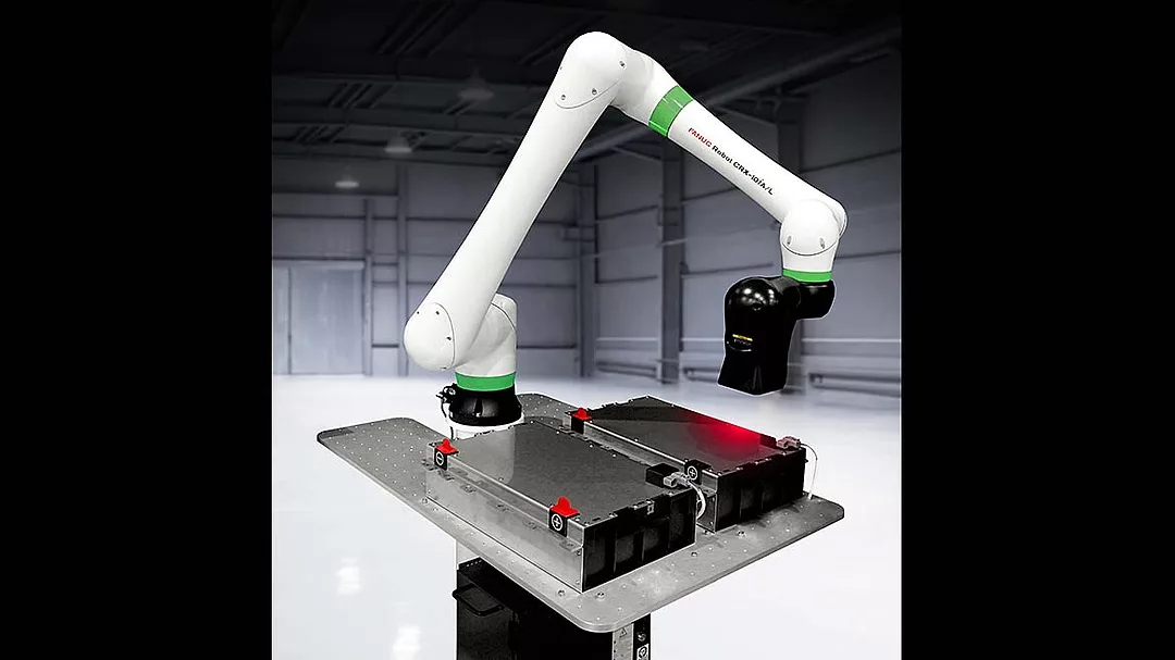 This is a FANUC CRX collaborative robot featuring a white arm with green accents performing industrial automation tasks