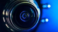 a close-up of a camera lens illuminated by blue backlighting