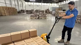 a yellow pallet jack being used in a warehouse setting