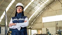 a person in industrial safety gear standing inside a facility
