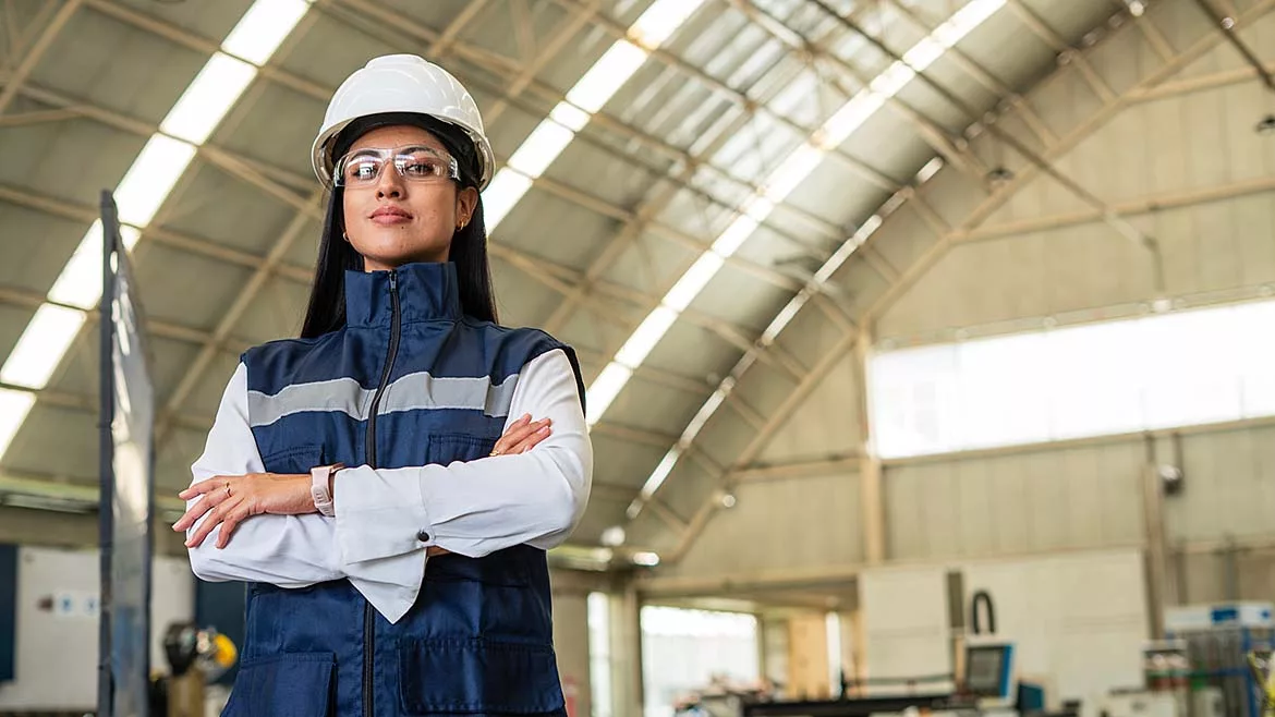 a person in industrial safety gear standing inside a facility