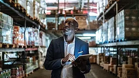 a warehouse manager using a digital tablet to take inventory